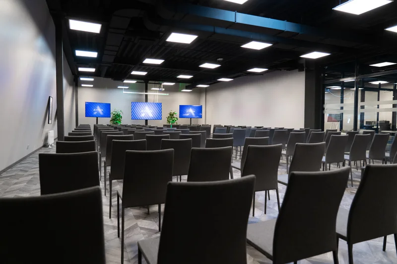 Konferenču zāle ATTA CENTRE ar rindu izkārtojumu un ekrānu